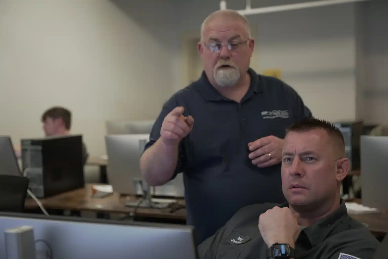 Professor pointing at a students screen helping them learn
