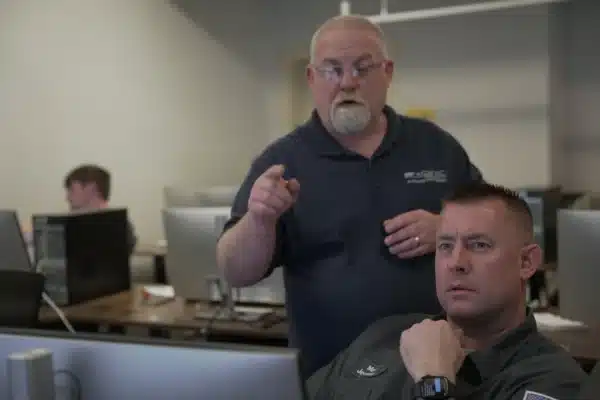 Professor pointing at a students screen helping them learn